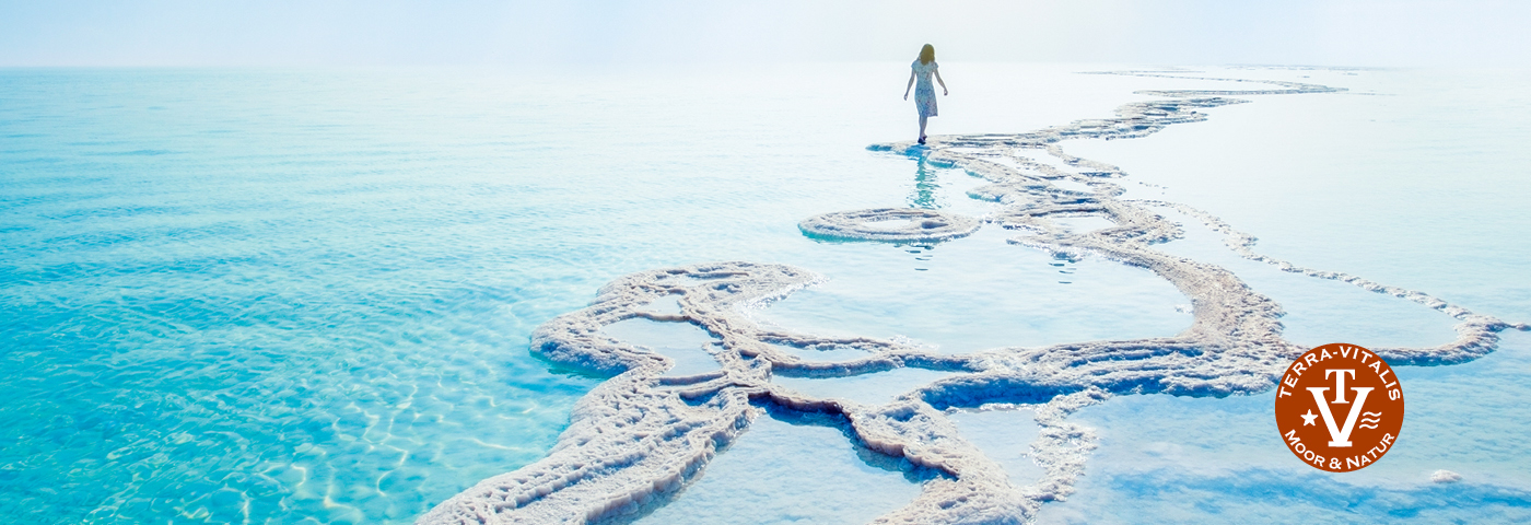 Totes-Meer-Salzgrotte - Frau im weißen Kleid spaziert am Strand