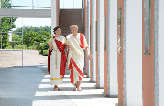 Führungen durch die Limes-Therme; römisch gekleidetes Pärchen 
