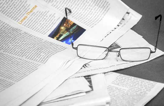 Pressestimmen über die Limes-Therme; symbolische Zeitung mit Brille
