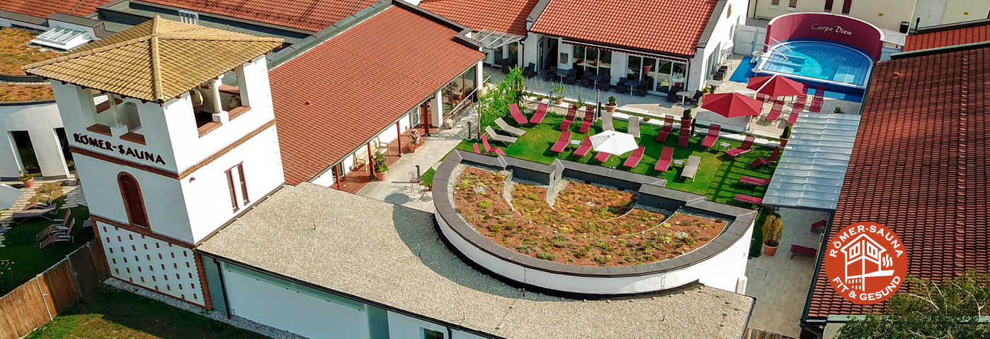 Luftansicht der Römersauna mit Turm und Gartenbereich mit Liegen